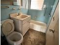 Small, outdated bathroom with blue tiling, vanity, toilet and bathtub at 1758 35Th St, Sarasota, FL 34234
