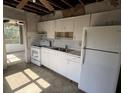 Outdated kitchen with white cabinets, white refrigerator and dated tile flooring at 1758 35Th St, Sarasota, FL 34234