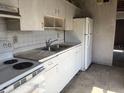Outdated kitchen with white cabinets, white refrigerator and dated tile flooring at 1758 35Th St, Sarasota, FL 34234