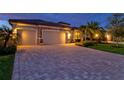 Inviting home exterior features a paver driveway, two-car garage, and lush landscaping at 17728 Polo Trail, Lakewood Ranch, FL 34211