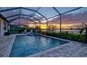 Relaxing screened-in pool and spa with pavers offers gorgeous lake views at 17728 Polo Trail, Lakewood Ranch, FL 34211
