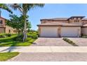 Beautiful exterior features a paver driveway, a two car garage and lush landscaping at 23528 Awabuki Dr # 101, Venice, FL 34293