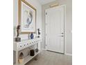 Inviting foyer with a decorative table, artwork, decor and tiled flooring at 23528 Awabuki Dr # 101, Venice, FL 34293