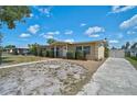 Side view of a single story home with landscaped yard and a long driveway, complemented by a sunny sky at 2708 27Th Avenue W Dr, Bradenton, FL 34205