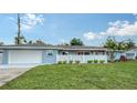 Ranch style home features a well manicured lawn and attractive landscaping for curb appeal at 2825 Pinecrest St, Sarasota, FL 34239