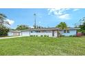Beautifully landscaped blue home featuring a well-manicured lawn and attached two car garage at 2825 Pinecrest St, Sarasota, FL 34239