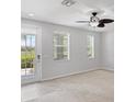 Bright living room with neutral carpet, ceiling fan, and a door to the outside at 3760 82Nd Avenue E Cir # 102, Sarasota, FL 34243