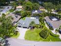 Aerial view of landscaped property with circular driveway, mature trees, and swimming pools in a quiet neighborhood at 3905 Country View Dr, Sarasota, FL 34233