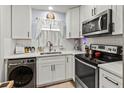 Well-lit kitchen featuring white cabinets, modern appliances, and durable countertops at 4189 Heron Way # 406E, Bradenton, FL 34205
