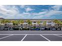 Multi-story condominium with covered parking and lush tropical landscaping of palm trees at 4310 Falmouth Dr # 105, Longboat Key, FL 34228