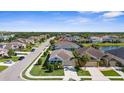 A scenic aerial view of a residential neighborhood with lush greenery and a serene pond at 4718 Arbor Gate Dr, Bradenton, FL 34203
