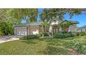 Beautiful one-story home featuring lush landscaping, a well-maintained lawn, and an attached two-car garage at 4920 Woodhurst Dr, Sarasota, FL 34243