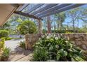 Charming courtyard featuring stone accents, lush plants, and a pergola for shade and visual interest at 5626 Pipers Waite # 22, Sarasota, FL 34235