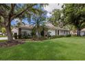 Charming home featuring a two-car garage, red tile roof, and mature trees at 5712 Garden Lakes Dr, Bradenton, FL 34203