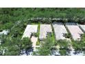 Aerial view of a home with a tile roof surrounded by mature trees and a lush green landscape at 5877 Ferrara Dr, Sarasota, FL 34238