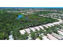 Expansive aerial view showcasing the home's location near a pond surrounded by mature trees at 5877 Ferrara Dr, Sarasota, FL 34238
