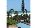 Lovely beach view with palm trees and ocean access from the condo, with beachgoers in the distance at 5916 Midnight Pass Rd # 404, Sarasota, FL 34242
