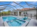A screened-in pool and spa area with clear blue water and lounge chairs at 7705 55Th E St, Ellenton, FL 34222