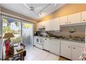 Cozy kitchen features white cabinetry, matching appliances, and sliding doors to the lanai at 805 Waterside Ln # 805, Bradenton, FL 34209