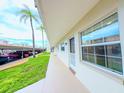Inviting exterior view of the apartment building with palm trees and assigned covered parking at 970 Virginia St # 109, Dunedin, FL 34698