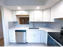 This updated kitchen features stainless steel appliances, white cabinets, and stylish backsplash at 970 Virginia St # 109, Dunedin, FL 34698