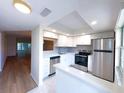 This updated kitchen features stainless steel appliances, white cabinets, and stylish backsplash at 970 Virginia St # 109, Dunedin, FL 34698