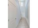 Bright hallway featuring tile flooring, a high ceiling, and a window for natural light at 10944 Rainbow Pyrite Dr, Wimauma, FL 33598