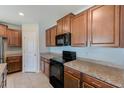 Kitchen showcases granite countertops, ample cabinet space, and modern black appliances at 10944 Rainbow Pyrite Dr, Wimauma, FL 33598