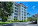 Low angle view of a condominium building on a manicured lawn under a sunny blue sky at 1100 Imperial Dr # 403, Sarasota, FL 34236