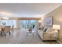 Bright living room with tile flooring, neutral paint, access to a balcony and view of the dining area at 1100 Imperial Dr # 403, Sarasota, FL 34236