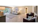 Bright living room with tile flooring, access to a balcony, neutral paint, and comfortable furnishings at 1100 Imperial Dr # 403, Sarasota, FL 34236