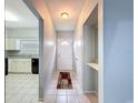 Inviting hallway with tile flooring leads to the kitchen with modern appliances and ample counter space at 11717 Wesson E Cir, Tampa, FL 33618