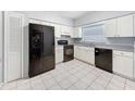 Well-lit kitchen featuring modern black appliances, ample counter space, and white cabinets at 11717 Wesson E Cir, Tampa, FL 33618
