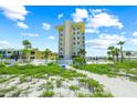 Exterior view of the beachfront condo with lush landscaping and community pool at 1255 Tarpon Center Dr # 309, Venice, FL 34285