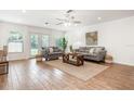 Bright living room with neutral decor, wood-look tile flooring, ceiling fan, and ample natural light from backyard access at 1345 24Th St, Sarasota, FL 34234