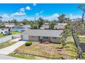 Aerial view of a single-story home featuring a well-maintained lawn, a one-car garage and a nearby pool at 1533 Olympia Rd, Venice, FL 34293