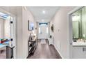 Inviting hallway with hard flooring, console table, and direct entry to the half bathroom at 16411 62Nd E Gln, Parrish, FL 34219