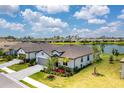 A single-Gathering home sits on a verdant lawn with views of a lake and beautiful landscaping around the property at 19801 Fishhawk Trl, Venice, FL 34293