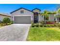 Beautiful single-Gathering home with a gray paver driveway and mature landscaping around the property at 19801 Fishhawk Trl, Venice, FL 34293