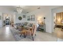 Cozy living room with a decorative chandelier and comfortable seating, neutral color palette and lots of natural light at 19801 Fishhawk Trl, Venice, FL 34293
