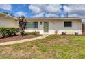 Close-up of the home's facade with a tidy lawn, well kept garden bed, and welcoming front door at 2402 33Rd W St, Bradenton, FL 34205