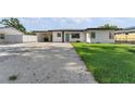 Charming single-story home with a carport and well-manicured lawn features fresh exterior paint at 2715 Herwald St, Sarasota, FL 34231