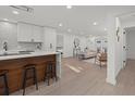 Open kitchen with white cabinets, a wood-accented island with seating, and recessed lighting at 2915 Woodpine Cir, Sarasota, FL 34231