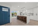 Modern kitchen featuring an island with seating, white cabinets, and a view from the front door at 2915 Woodpine Cir, Sarasota, FL 34231