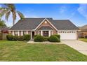 Charming single-story home with a well-manicured lawn, mature landscaping, and a two-car garage at 3910 77Th E Pl, Sarasota, FL 34243