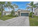 Well maintained property with a spacious driveway leading to an attached garage, framed by lush landscaping at 4103 61St E Ave, Bradenton, FL 34203