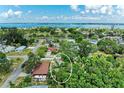 Aerial view of a home surrounded by lush greenery and trees, with a glimpse of the ocean in the distance at 4115 2Nd Nw Ave, Bradenton, FL 34209