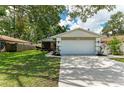 Exterior view of home with a lush green lawn and an attached two-car garage, with a boat and trailer parked on the side at 4115 2Nd Nw Ave, Bradenton, FL 34209
