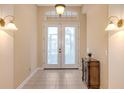 Bright foyer featuring tile flooring, decorative sconces, and a frosted glass double door at 4274 Tennyson Way, Venice, FL 34293