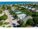 Aerial view of a charming coastal home with a pool surrounded by palm trees and neighboring houses at 507 Spring Ave, Anna Maria, FL 34216